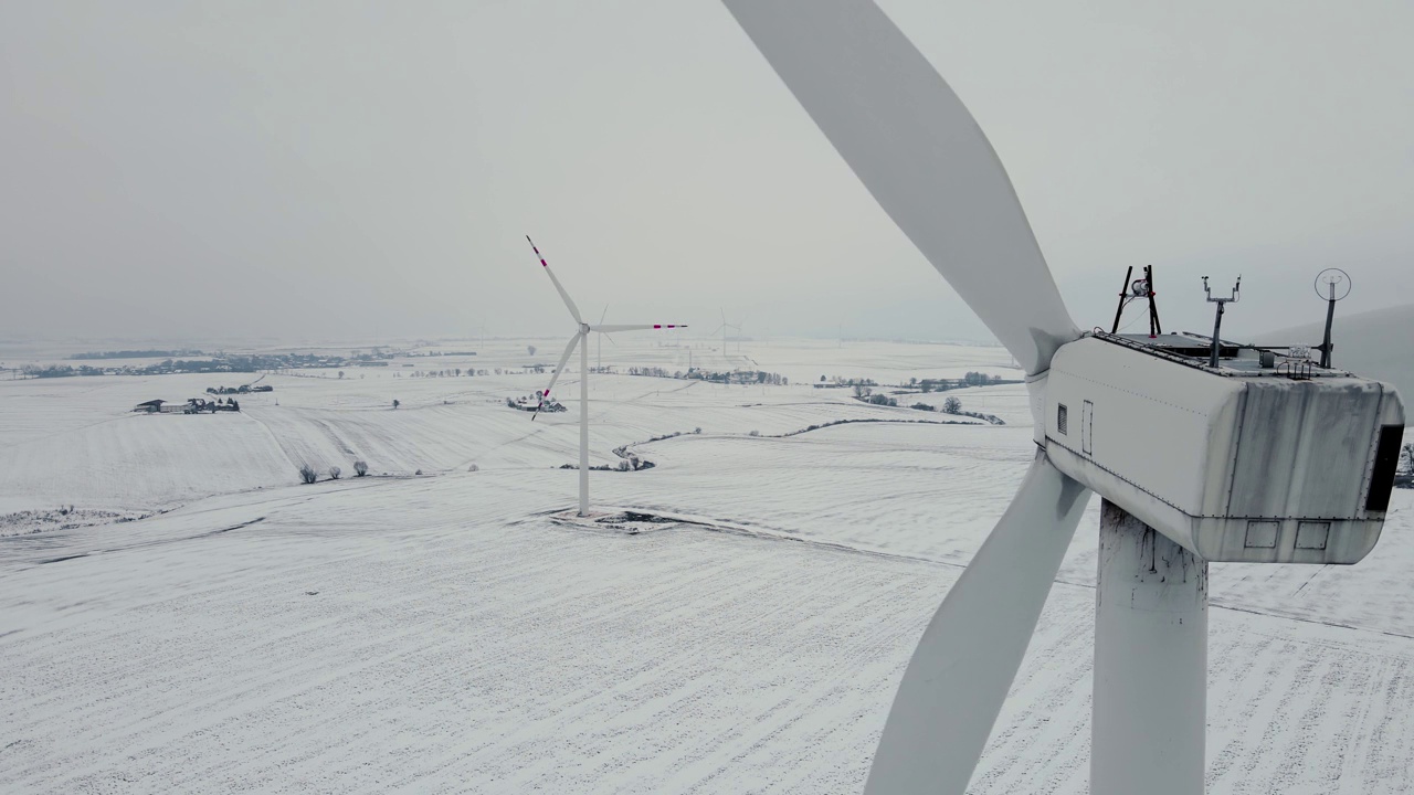 大型风力涡轮机与叶片在野外鸟瞰图在寒冷冻结雪的冬天视频素材