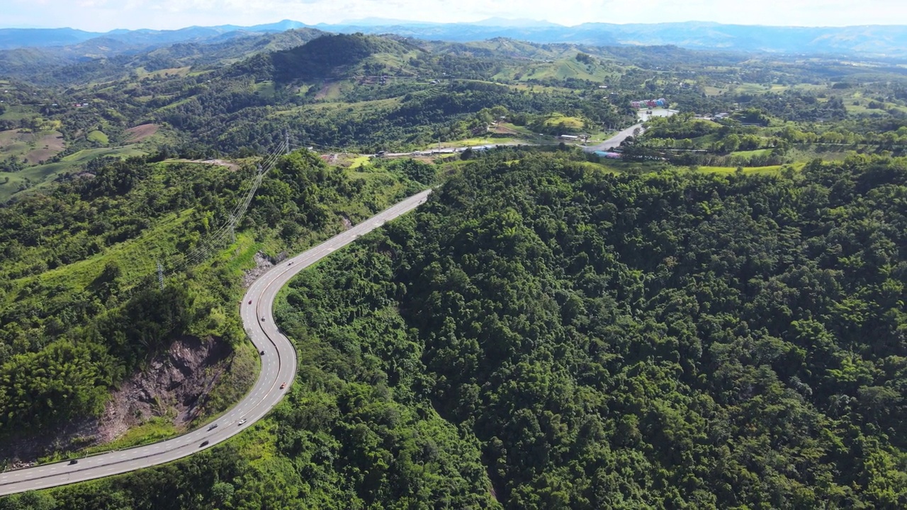 乡村道路穿过绿色的森林和山脉。视频素材