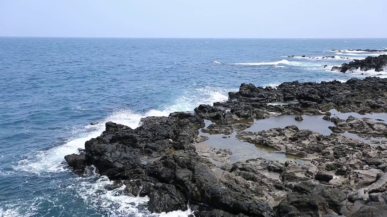 在济州岛，美丽的海浪拍打着玄武岩海滩的视频视频素材