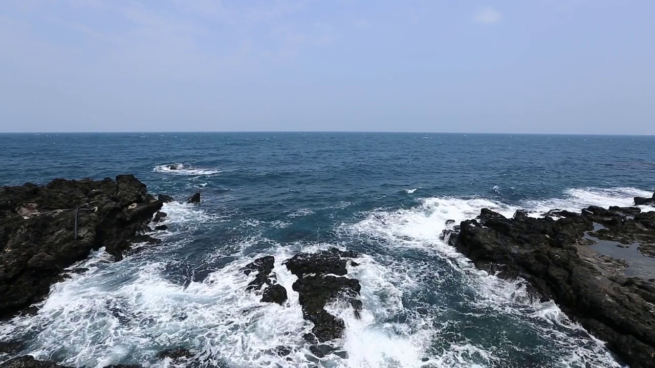 在济州岛，美丽的海浪拍打着玄武岩海滩的视频视频素材