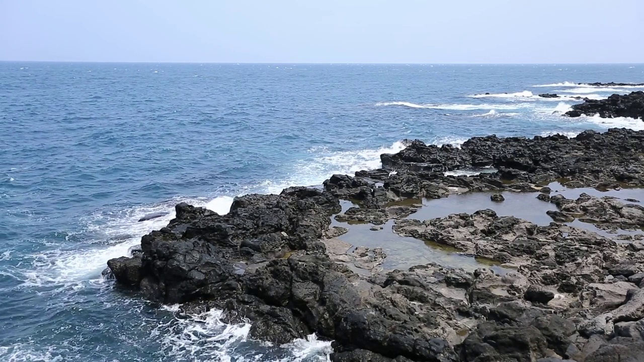 在济州岛，美丽的海浪拍打着玄武岩海滩的视频视频素材