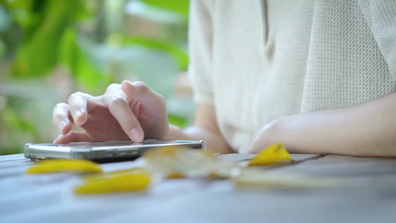 商务女性的手在工作或网上购物从咖啡店在假期期间被花园树木和放松的气氛包围。视频素材