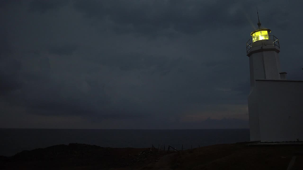 灯塔在黄昏时燃烧。灯塔在阴雨中发光。视频下载