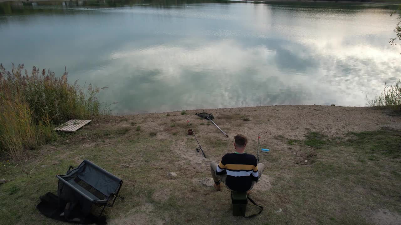 飞过湖面，仿佛垂钓者坐在岸边垂钓视频素材