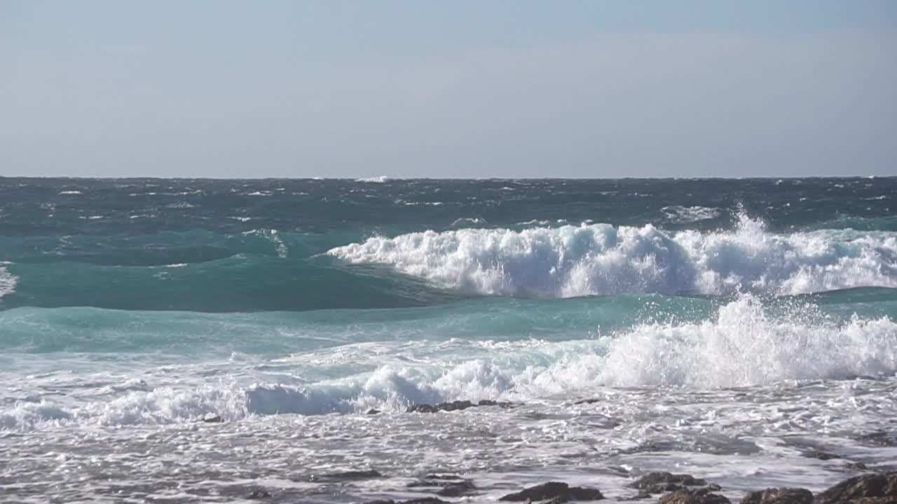 在暴风雨后的一个阳光灿烂的日子里，海浪碾压海岸线的慢镜头特写视频素材