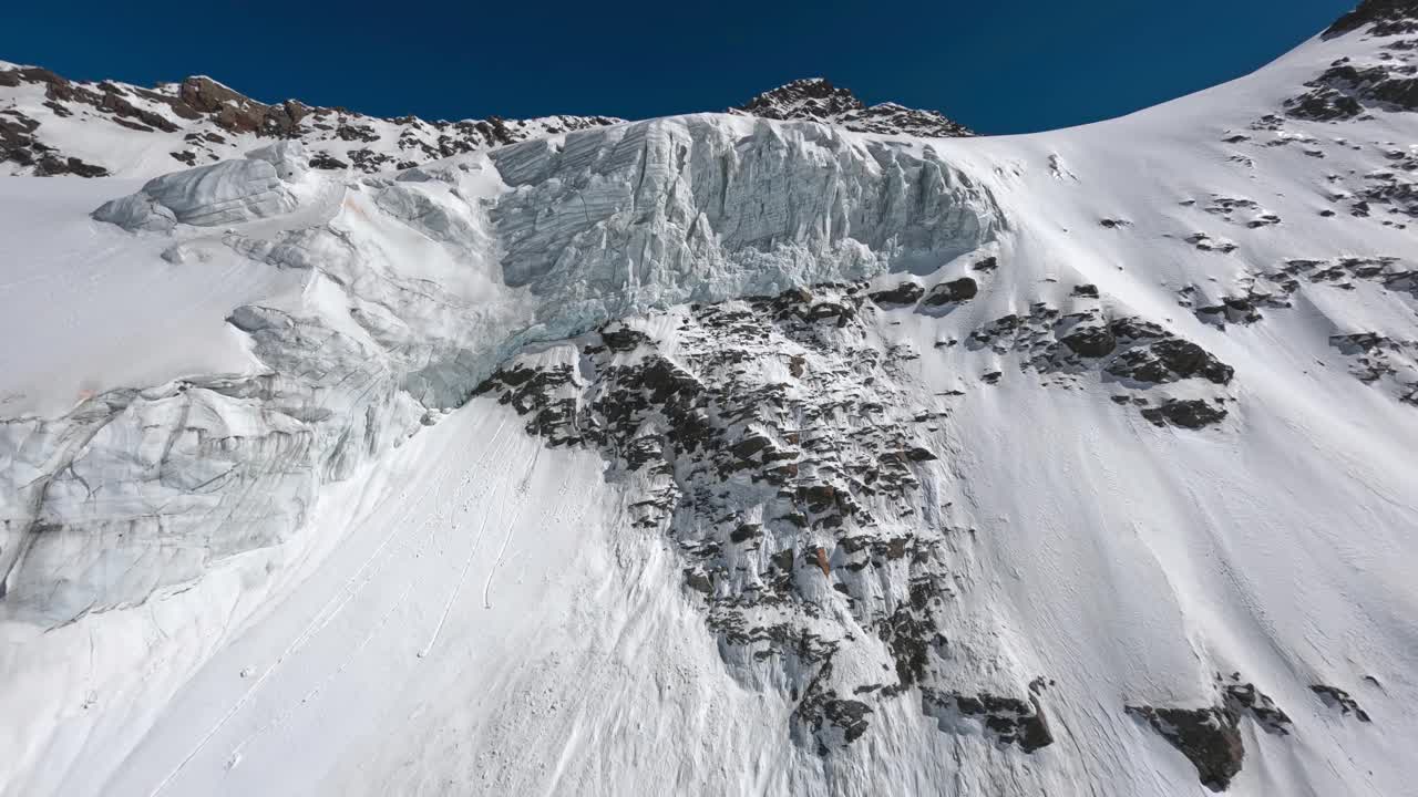 高山冰川冰结构雪冬季阳光山谷悬崖顶峰高度空中全景视图视频素材