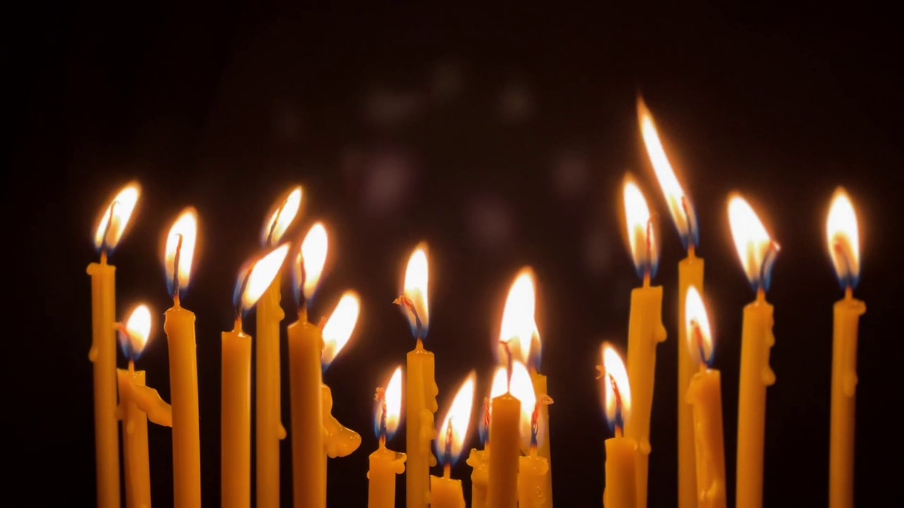许多蜡薄的蜡烛明亮地燃烧着。宗教的概念。视频素材