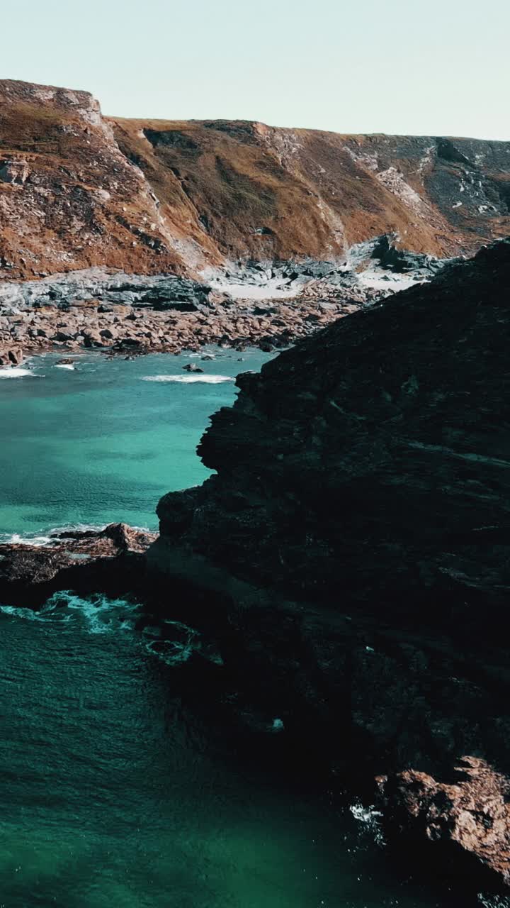 海洋海岸线的岩石与蓝绿色的水垂直视频视频素材