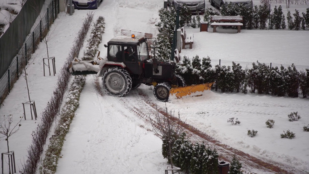 在城市里，拖拉机用刷子清理积雪视频素材