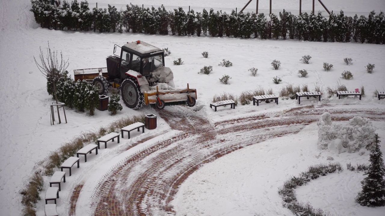 在城市里，拖拉机用刷子清理积雪视频素材