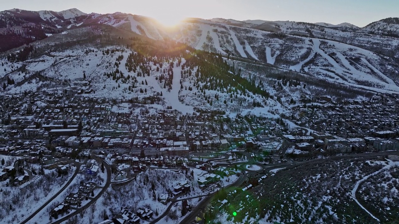 犹他州帕克城航拍v20飞越山坡的历史老城区，被雪山环绕，冬季太阳在山脊之间落下——用Mavic 3 Cine拍摄——2022年2月视频素材