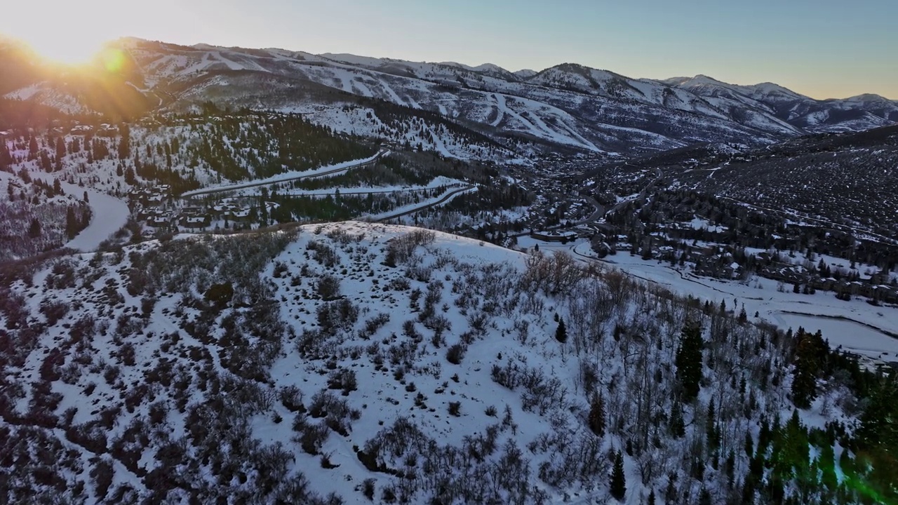 犹他州帕克城空中v22无人机飞越山脊，捕捉白雪皑皑的山景，蜿蜒的山路和山麓滑雪小屋，拥有美丽的日落美景-由Mavic 3 Cine拍摄- 2022年2月视频素材