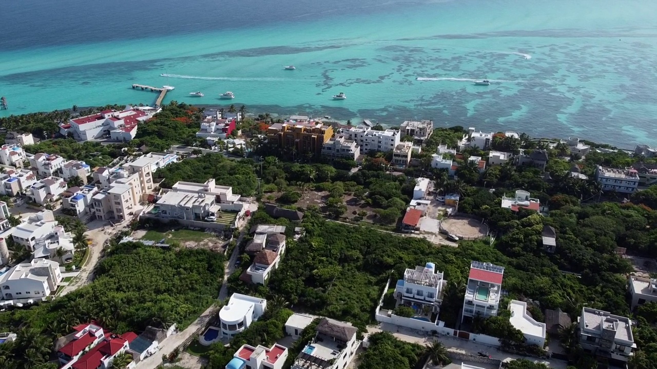 无人机在墨西哥金塔纳罗奥岛的Isla Mujeres岛南部的房屋和酒店上空向前移动。视频素材