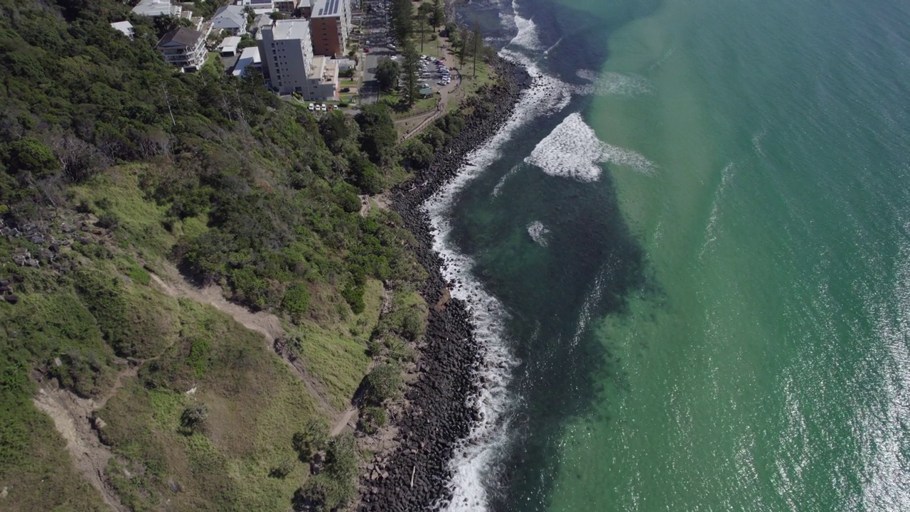 海浪冲击着澳大利亚昆士兰的伯利海德国家公园的岩石海岸。——空中视频素材