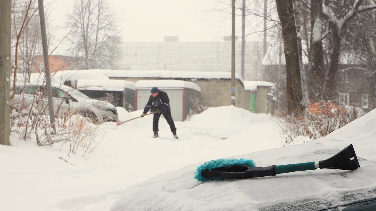 一个人用散焦铲雪，正在下雪。视频下载