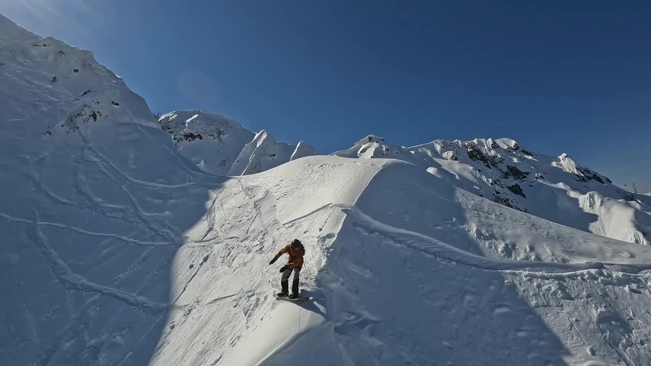 FPV无人机跟随滑雪板骑雪山顶峰极限运动自由骑行视频素材