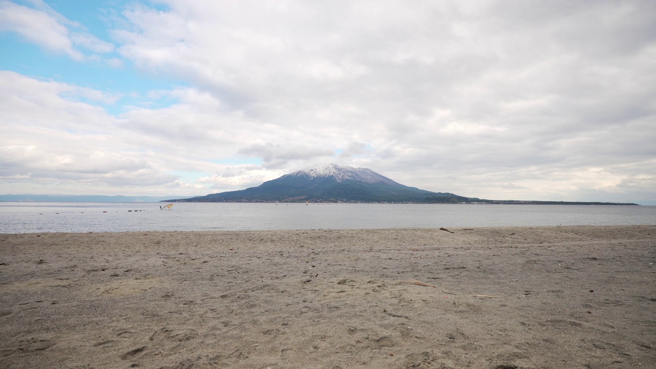 从海滩上看，美丽的白雪覆盖着樱岛视频素材