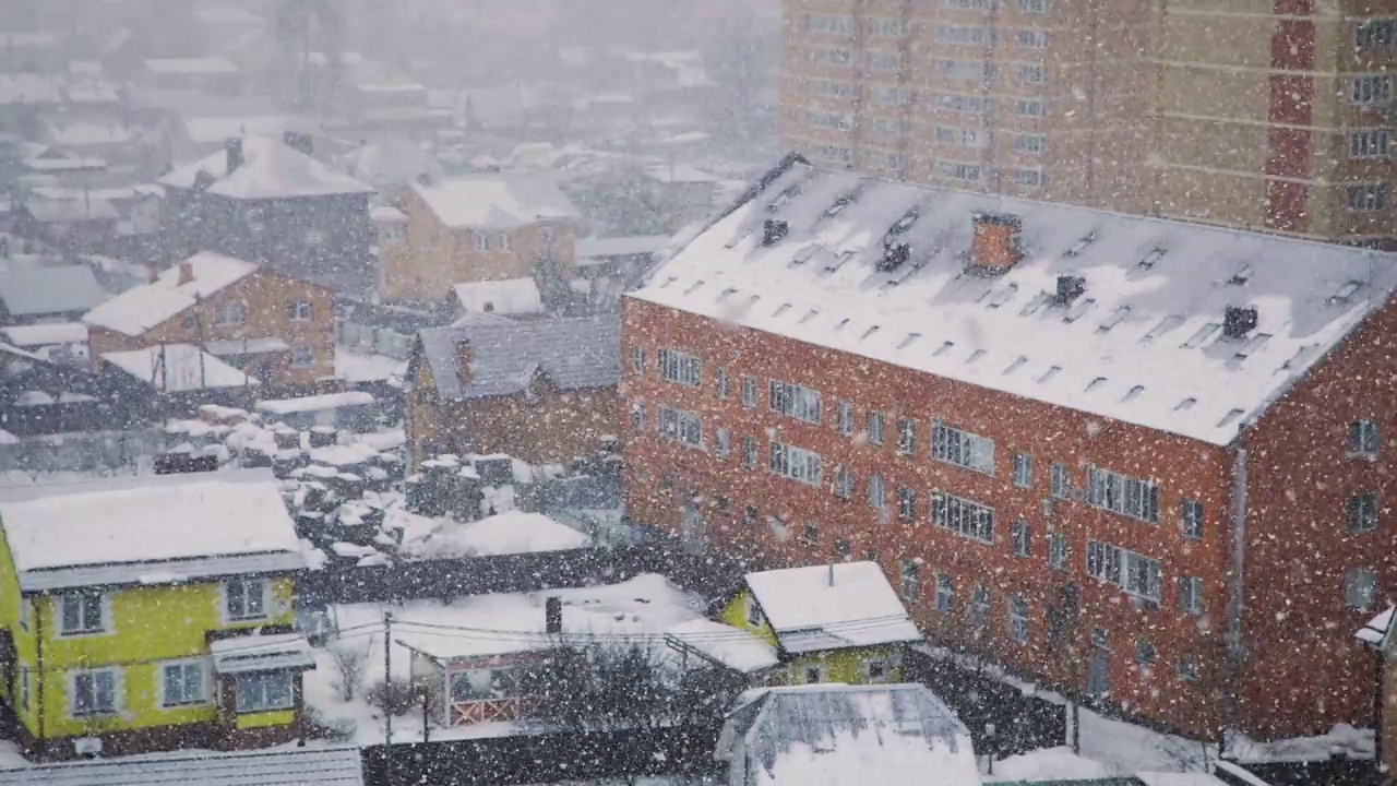 大片蓬松的雪花覆盖了城市，一场暴风雪。慢动作视频素材