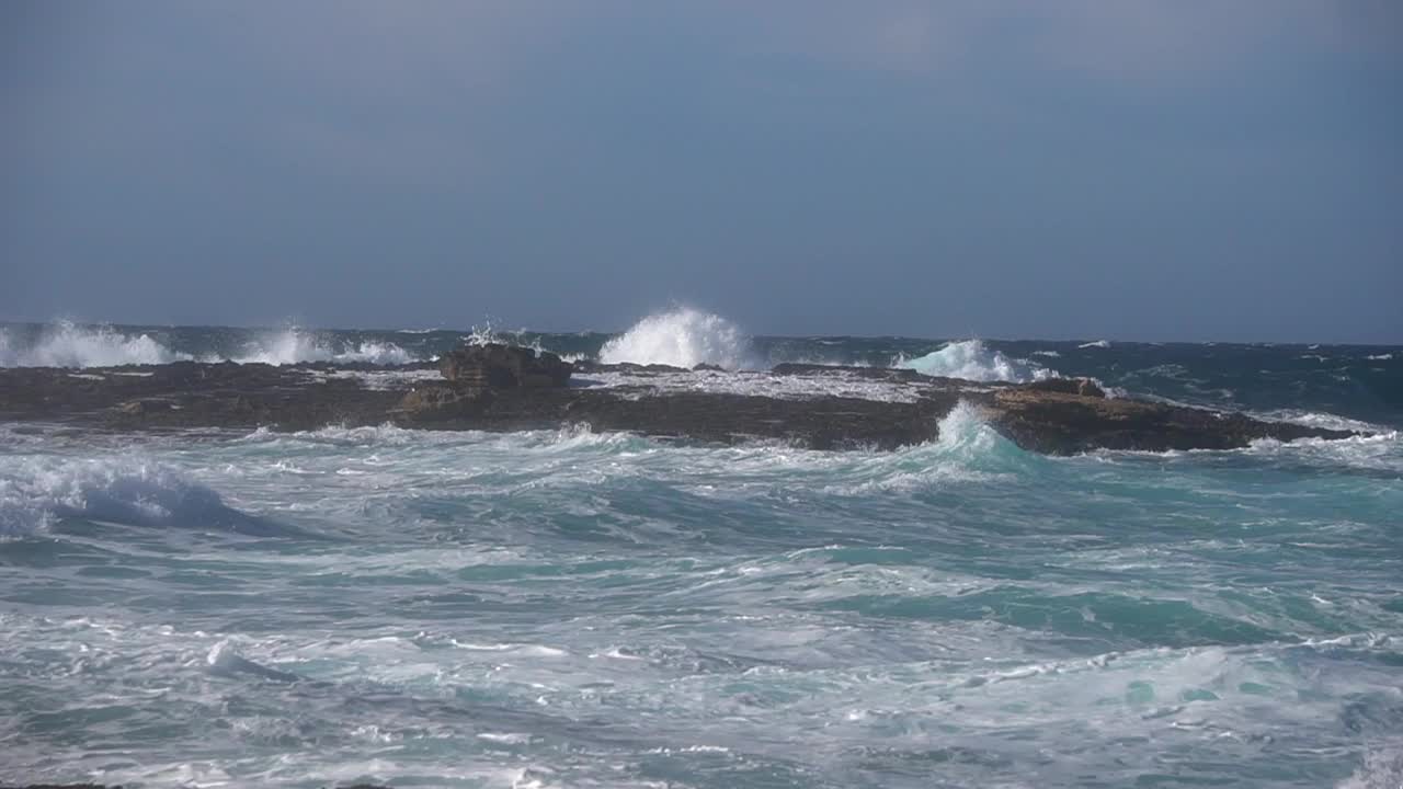 暴风雨后海浪撞击海岸线前小岛的慢镜头视频素材