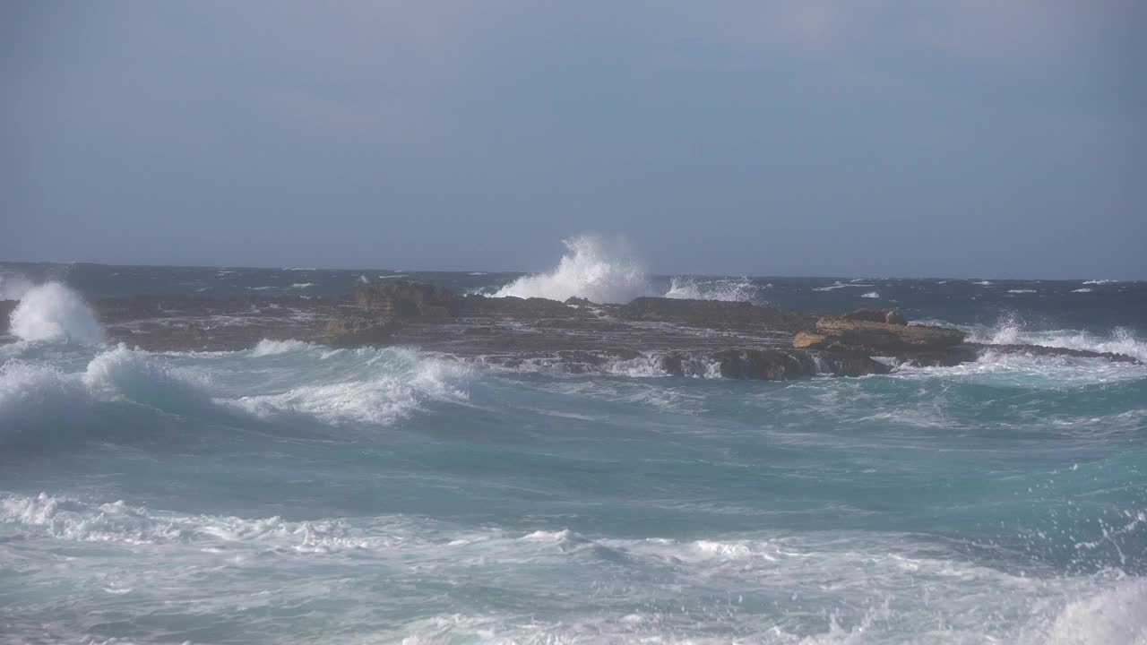 暴风雨过后，海浪冲击着海岸线前的一个小岛视频素材