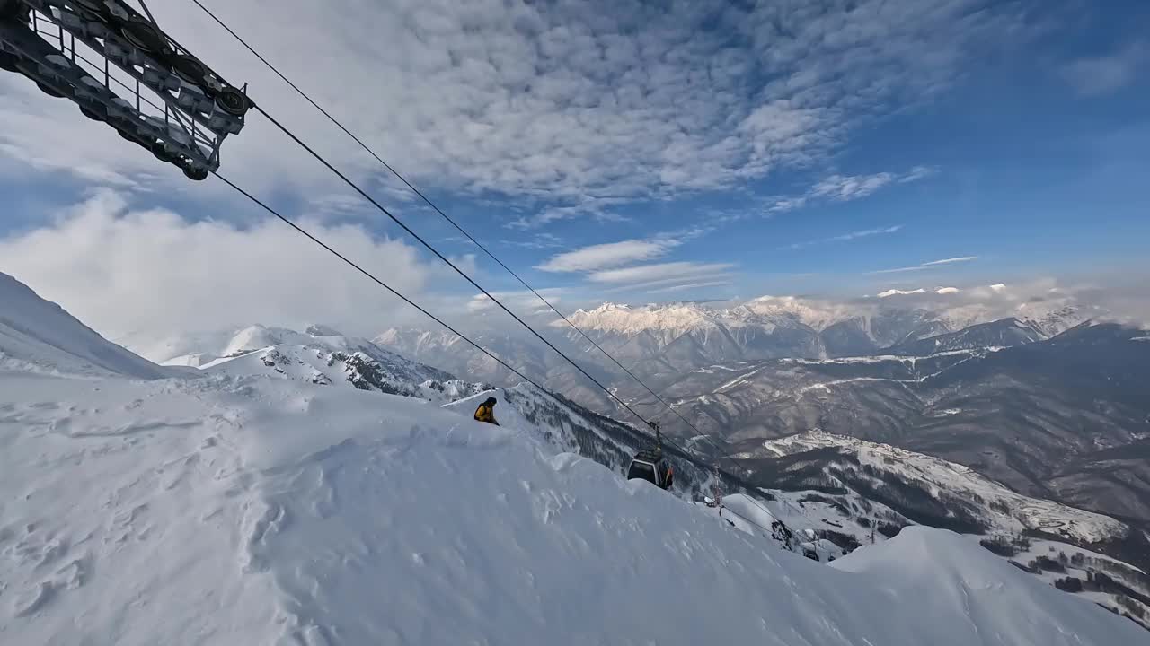 运动FPV无人机周围跟随观看男子骑单板滑雪特技山视频素材