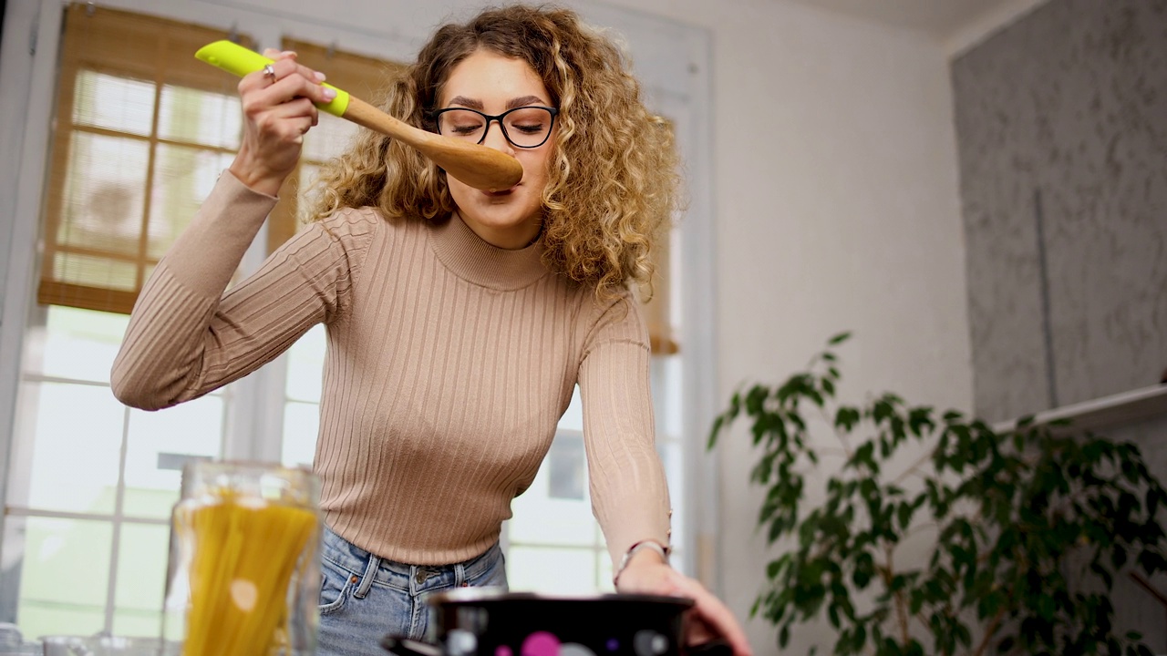 年轻漂亮的女人在家里做饭视频素材