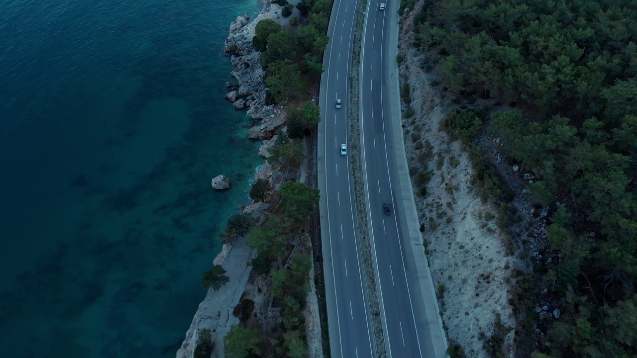 摄影机在傍晚飞过位于海边的道路。视频素材