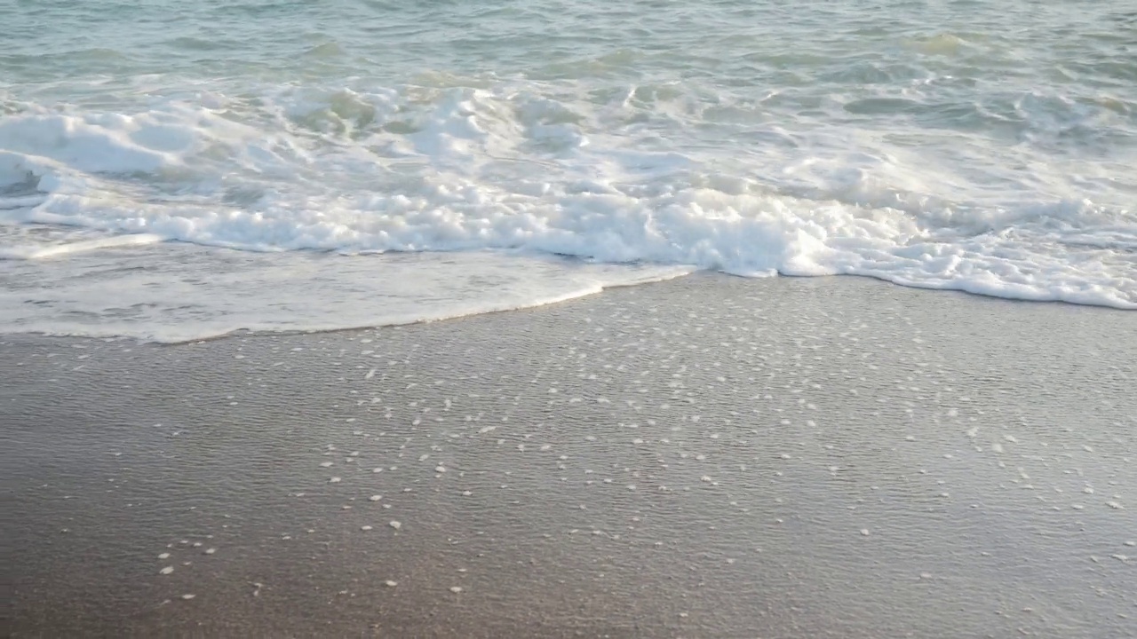 海洋主题的背景。波浪冲刷着沙滩。视频素材