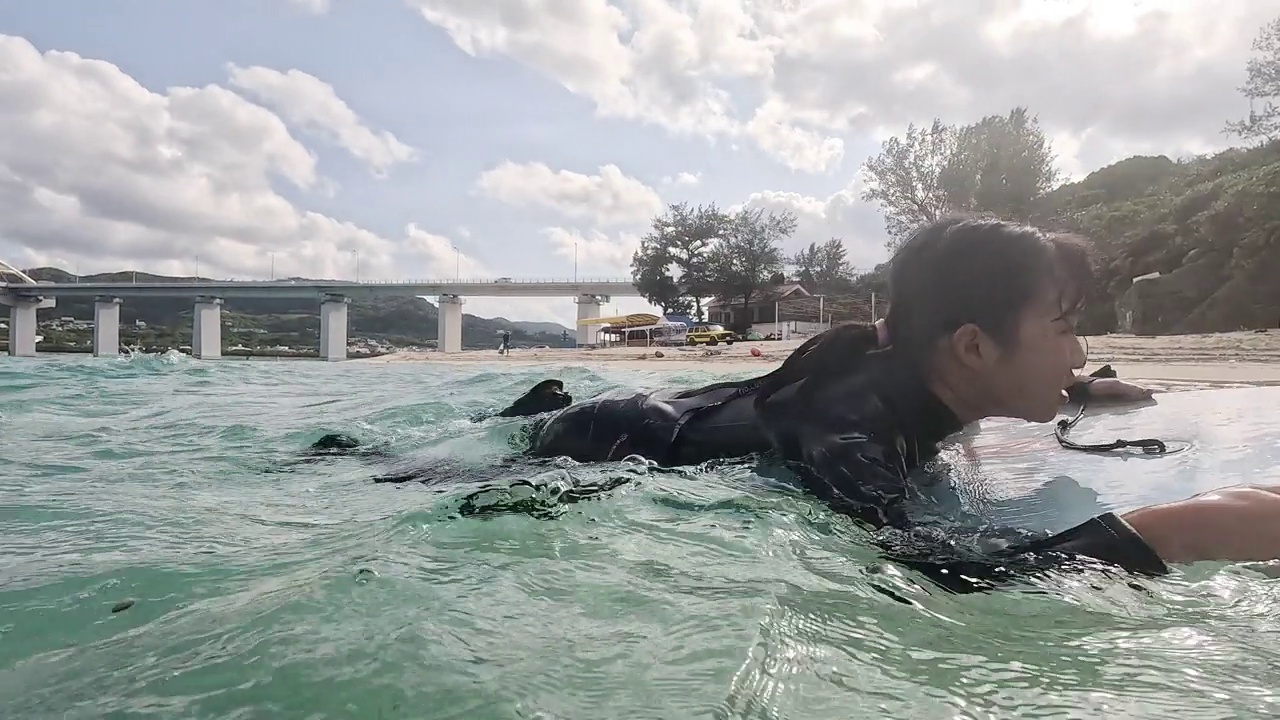 一个十几岁的女孩在冲浪板上踢鳍视频素材