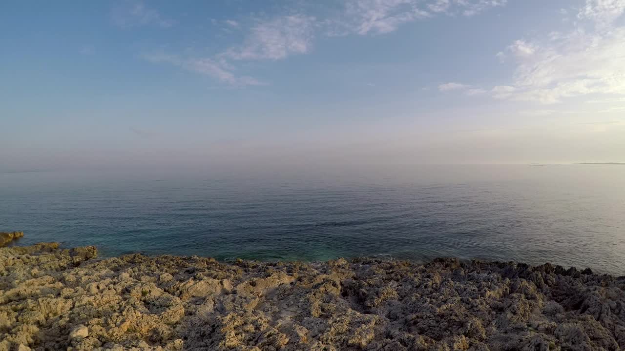 在多云的天空下，鸟瞰美丽的蓝色大海和平静的海浪视频素材