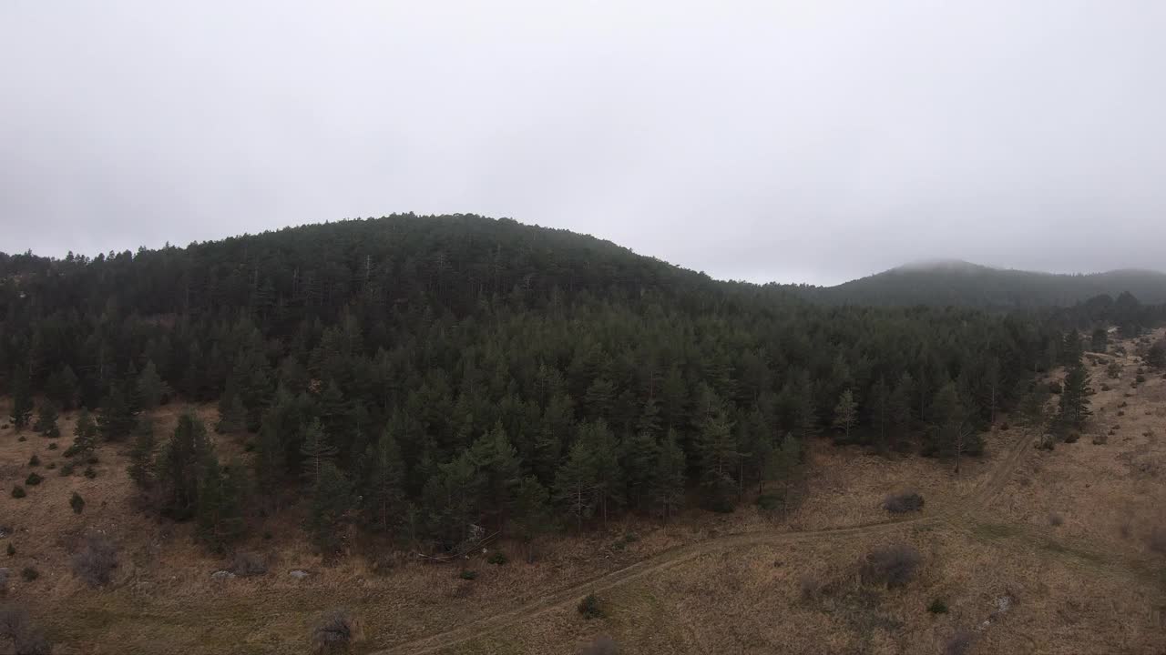 秋天的一天，穿着红色运动服的女孩在以山林为背景的田野里奔跑视频素材