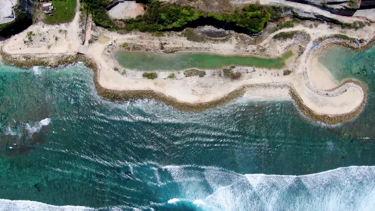 巴厘岛标志性的蓝色海洋和沙滩与建筑，自上而下的观点视频素材