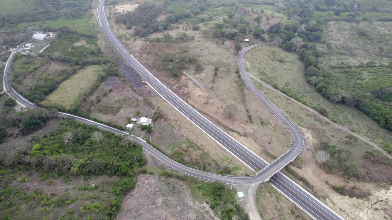 鸟瞰覆盖着绿色灌木的田野中的道路视频素材