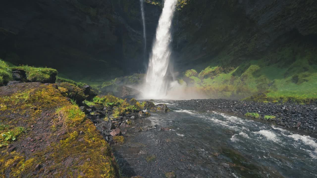 Kvernufoss瀑布流动与彩虹发光隐藏在苔藓岩石峡谷的夏天在冰岛视频素材