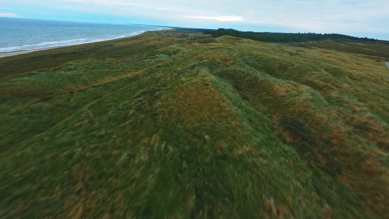 无人机在海边山丘崎岖的地形上空飞行视频素材