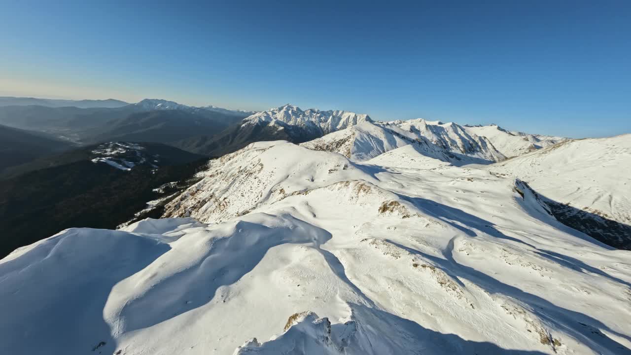 极速俯冲飞越山脊峰顶雪景如画的小山海拔野生视频素材