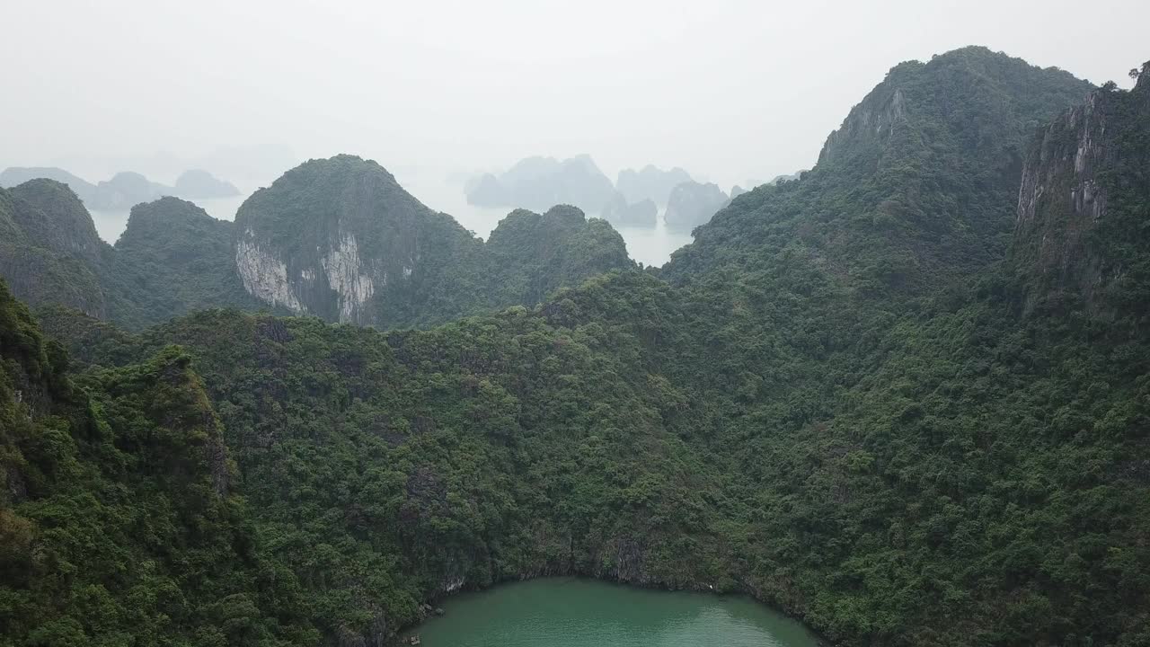 航拍越南广宁下龙湾翠绿的海水和森林覆盖的山脉视频素材