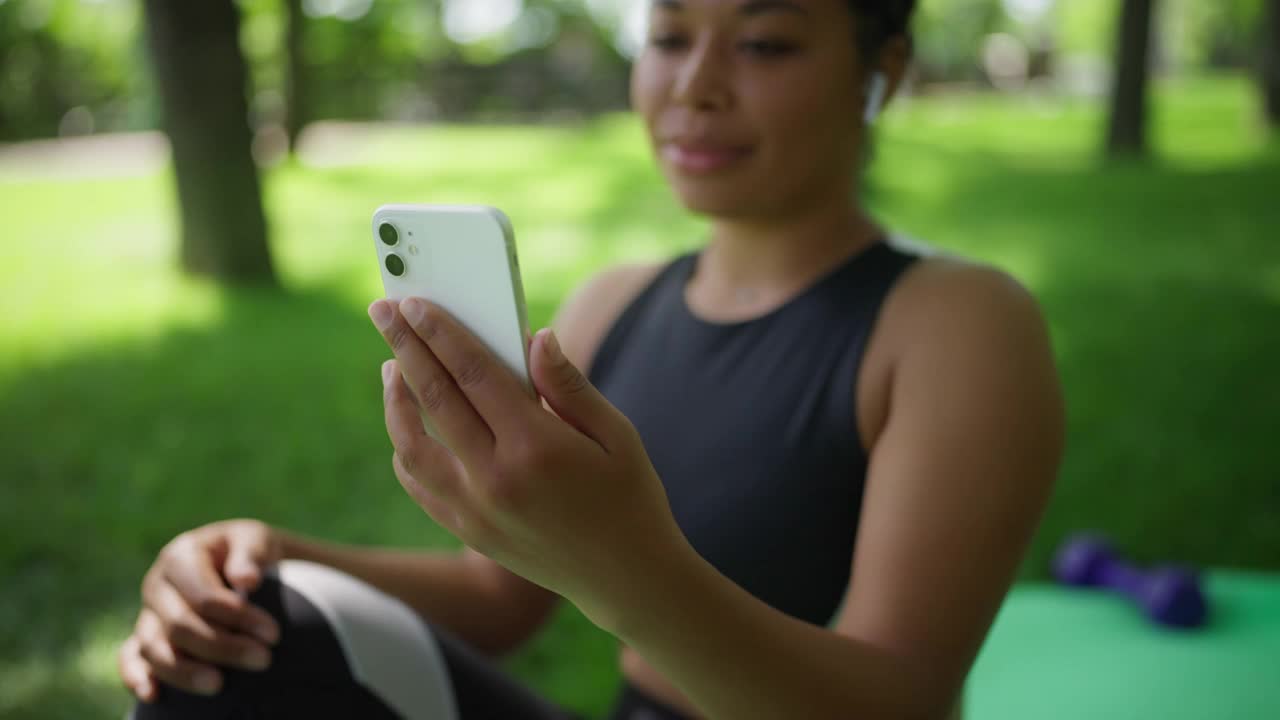 特写非裔美国妇女在公园锻炼后进行在线视频通话视频素材