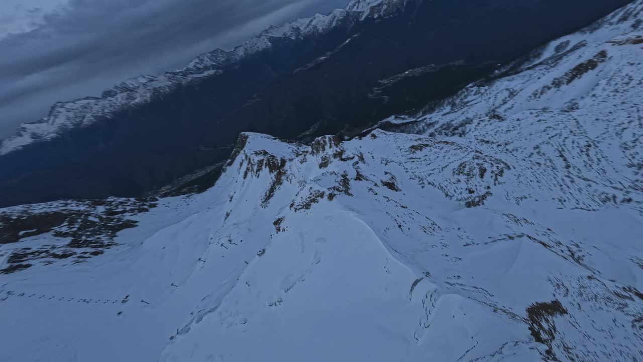 高山滑雪山脊悬崖雪峰石纹理山脊海拔戏剧性的夜间云景视频素材