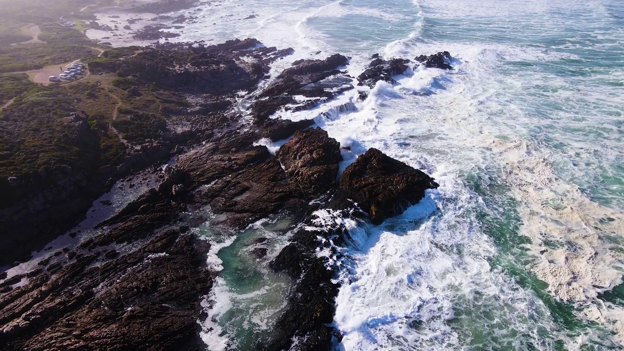 在岩石海岸线上的空中立管，海浪不断翻滚;Hermanus视频素材