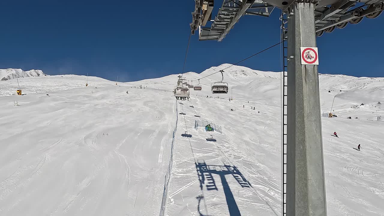 Passo del Tonale, Ponte di Legno，意大利。在一个阳光明媚的日子里，滑雪者在缆车上移动到滑雪道的顶部。最佳滑雪场视频素材