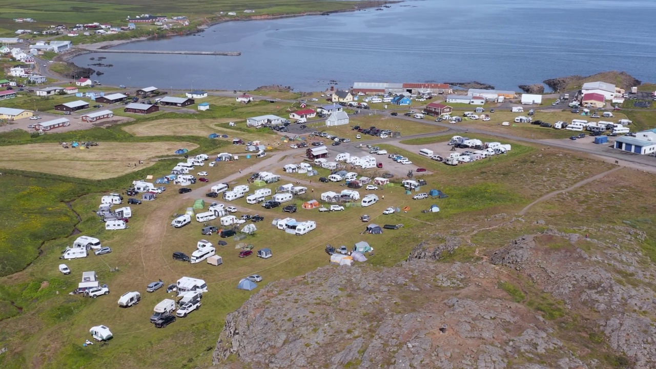 Tourist camp ground filled with tents and campers on sunny day in Borgarfjörður视频素材