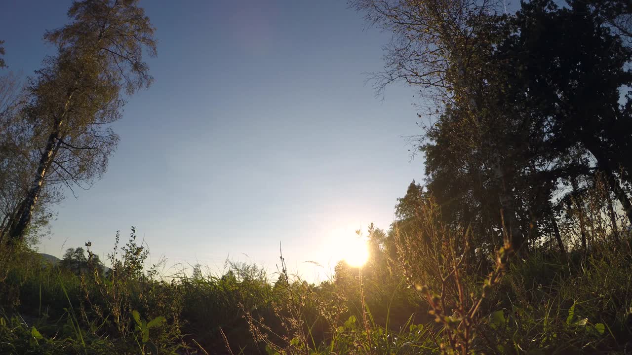 一个年轻女孩在夕阳下奔跑的低角度镜头视频素材