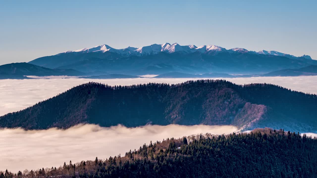 阿尔卑斯山脉的全景之上，雾蒙蒙的云快速移动在山谷在寒冷的冬天早晨自然时间推移视频素材