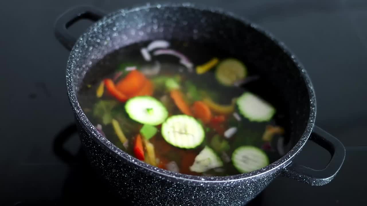 蔬菜是用砂锅煮的。蔬菜在装有热水的锅里旋转。素食主义和健康有机食品的概念视频素材