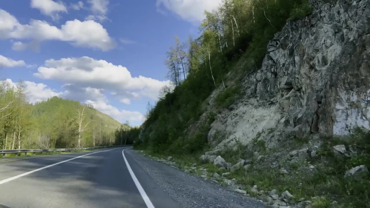 汽车在青山丛中沿着蜿蜒的山路行驶。视频素材