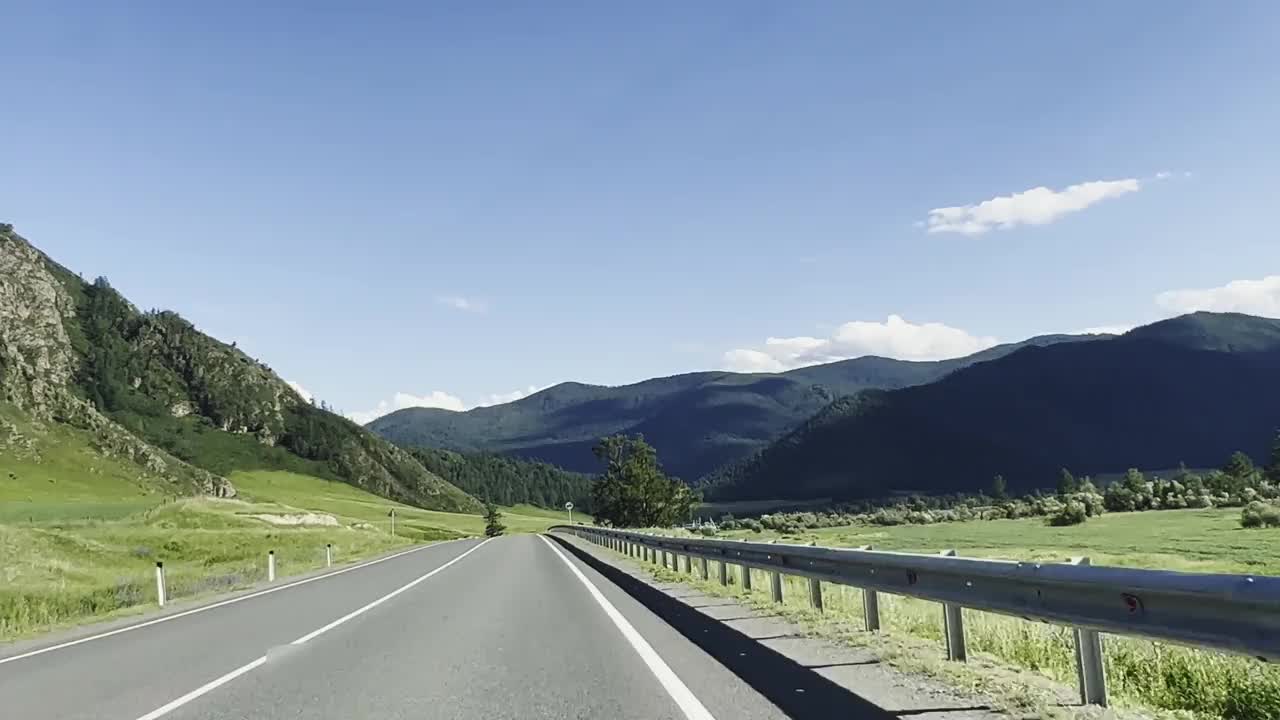 汽车在风景的背景下沿着山路行驶。视频素材