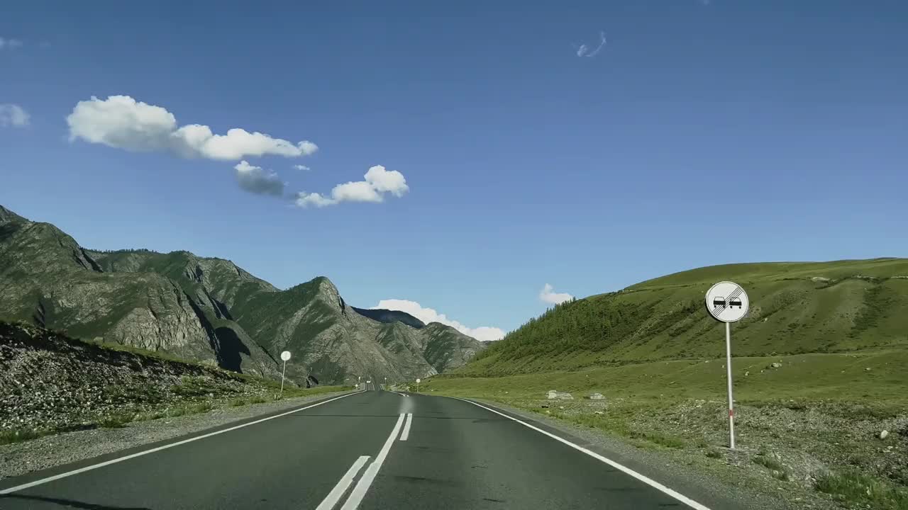 汽车在风景的背景下沿着山路行驶。视频素材