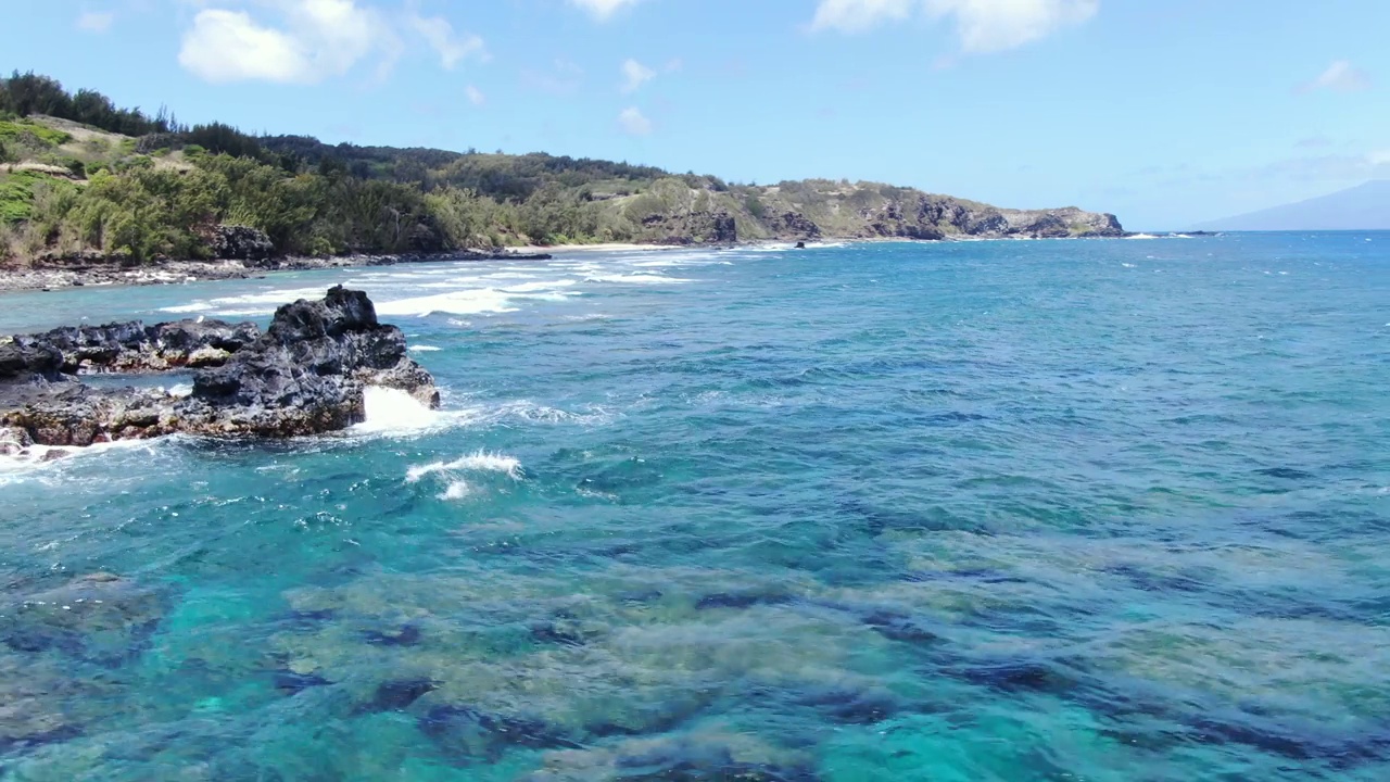 毛伊岛的普纳劳海滩。空中:晶莹剔透的蓝绿色海水翻滚在崎岖的海岸线珊瑚礁上。视频素材