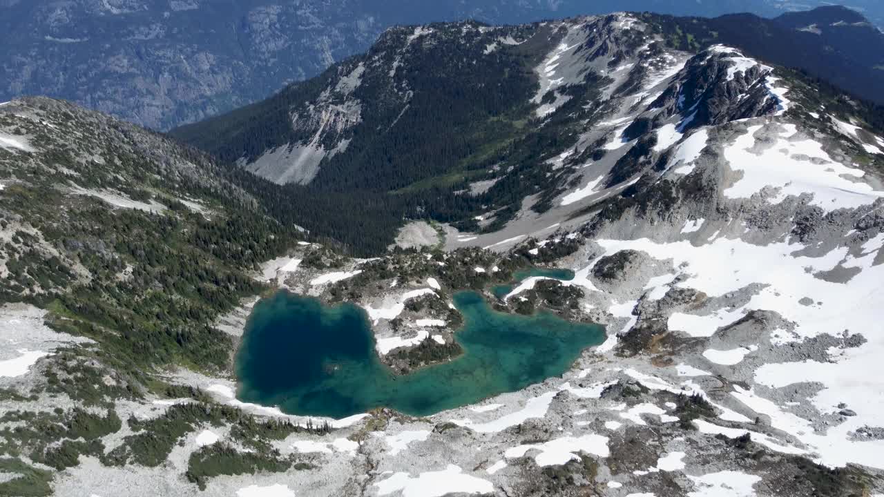 鸟瞰蓝绿色的湖，揭示了加拿大Sugarloaf峰Pemberton Meadows附近朦胧的山地景观-无人机镜头4K视频素材